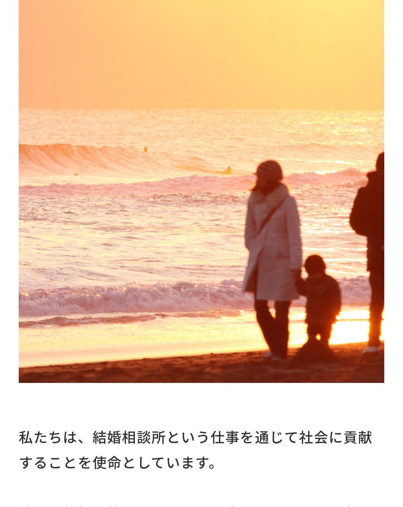 夕陽の海岸を歩く家族
