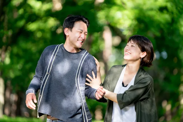 デート中のカップルが自然の中で笑い合う様子